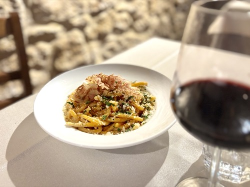 Pici con guanciale croccante e un calice di vino rosso